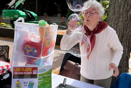Woman blowing bubles with soap detergent bottles nearby