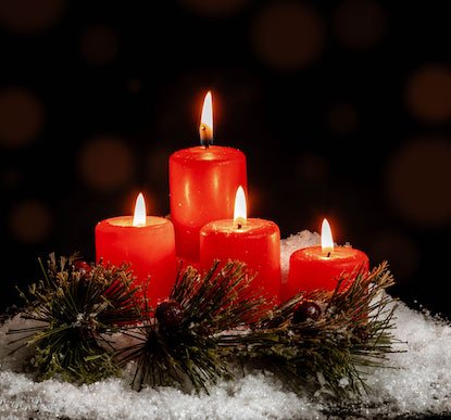 Red candles burnig with greens and white snow