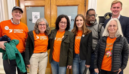 A group of people standing together with orange t shirts