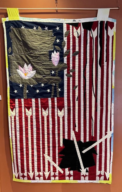 An American flag quilted piece with pieces added on.