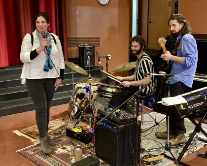 Band with singer at microphone base and drum players