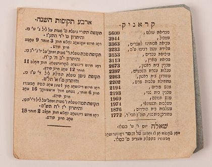 Old Hebrew calendar in an old book with tattered pages.