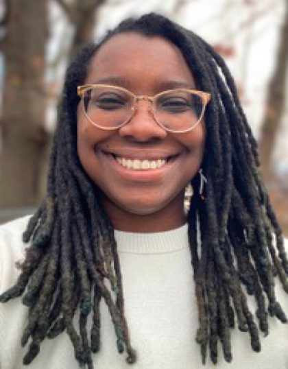 A smiling black girl with glasses and long dark hair