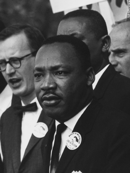 a black and white photo of Martin Luther King in a crowd at the I have a Dream rally
